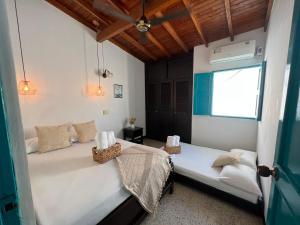 多拉代尔Cabaña La Aldea - Santorini Colombiano的一间卧室设有两张床和窗户。