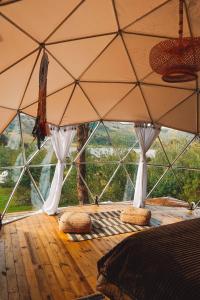 苏埃斯卡Alma de Campo Glamping - Laguna de Suesca的客房铺有木地板,配有带枕头的大型帐篷。