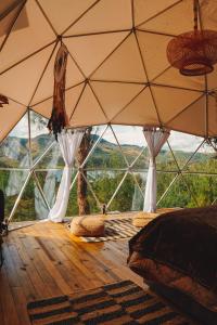 苏埃斯卡Alma de Campo Glamping - Laguna de Suesca的客房设有带床和枕头的大窗户。