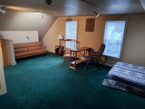 KingfieldTerrapin Hostel的一间卧室配有一张床、一张沙发和一张桌子