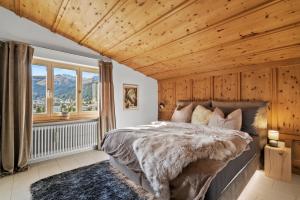 达沃斯A&Y Chalet zum goldenen Hirsch的一间卧室设有一张床和木制天花板