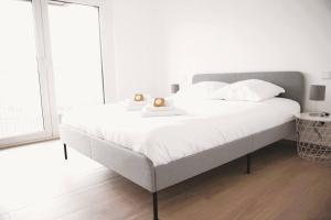 卢森堡Beautiful Stylish 2BR Apartment in Kirchberg的白色卧室配有一张带白色床单的大床