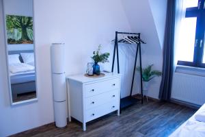 威斯巴登BeMyGuest - 3 Zimmer Maisonette - Zentral - Klimaanlage - Aufzug的卧室配有白色梳妆台和1张床