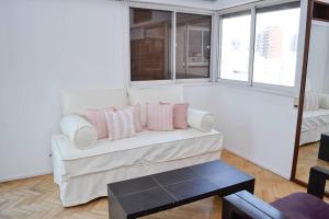 奥利沃斯Libertador 2785 by depptö的客厅配有带粉红色枕头的白色沙发