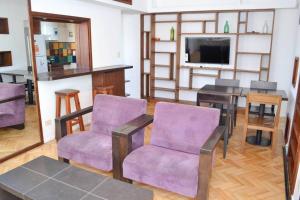 奥利沃斯Libertador 2785 by depptö的客厅配有紫色椅子和桌子