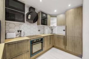 泰晤士河畔金斯顿Luxury Apartment in Kingston的一个带木制橱柜和水槽的小厨房