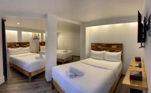 长滩岛El Puerto Boracay Shore的酒店客房,配有两张带白色床单的床