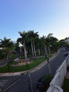 贝洛奥里藏特Portal do Jaragua的一条棕榈树的空街和路边的一辆汽车
