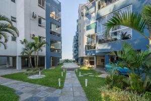 伊塔佩马Apto com churrasqueira privativa Itapema-SC CPE203的公寓大楼拥有棕榈树和建筑