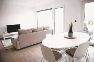 卢森堡Beautiful 2BR Apartment in Kirchberg的白色的客厅配有桌子和沙发