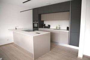卢森堡Beautiful 2BR Apartment in Kirchberg的厨房配有白色的柜台和黑色的橱柜