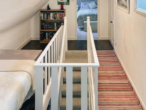 MarvigSouth Lochs的通往卧室的楼梯,卧室配有一张床