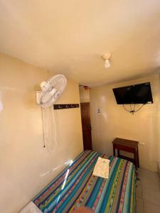 HuaquillasHotel RODEY的卧室配有一张床铺,墙上装有风扇
