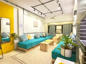 孟买Locomo Express - Stay Work Eat的客厅配有沙发和桌子