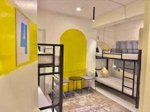孟买Locomo Express - Stay Work Eat的客房设有两张双层床和黄色的墙壁