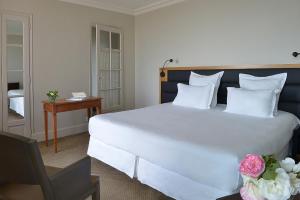 勒克鲁西克的奥欧深格兰德酒店的卧室配有一张白色的大床和一张桌子