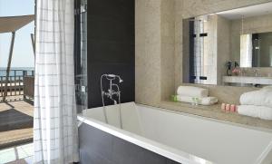 勒克鲁西克的奥欧深格兰德酒店的带浴缸和镜子的浴室