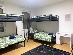 伍珀塔尔Shared Serenity accommodation的客房设有三张双层床和一张书桌。