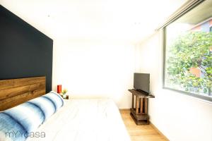 墨西哥城Sophisticated Park Venue Apartment Near Polanco - Nadal 101的一间卧室设有一张床和一个大窗户