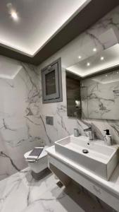 伊奥斯乔拉Ambiente Luxury Suites的白色的浴室设有水槽和卫生间。