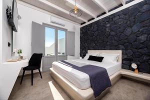 伊奥斯乔拉Ambiente Luxury Suites的一间卧室设有一张床和一面岩石墙