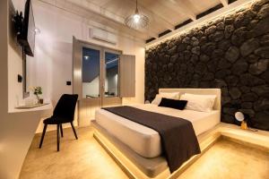 伊奥斯乔拉Ambiente Luxury Suites的一间卧室设有一张床和石墙