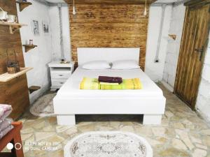 波德戈里察Villa Old Town的卧室配有白色的床和木墙