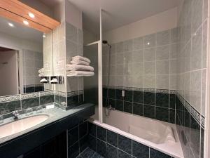 菲雅克朋杜贝斯特韦斯特酒店的浴室配有盥洗盆和浴缸。