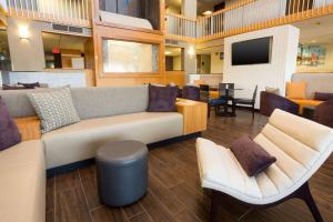 奥斯汀Drury Inn & Suites Austin North的大堂配有沙发、椅子和电视