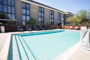 奥斯汀Drury Inn & Suites Austin North的大楼前带椅子的大型游泳池
