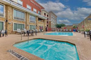 圣安东尼奥Drury Inn & Suites San Antonio Airport的一座带椅子的游泳池以及一座建筑