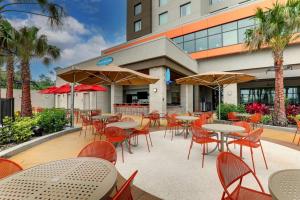 奥兰多Drury Plaza Hotel Orlando - Disney Springs Area的一个带桌椅和遮阳伞的户外庭院。
