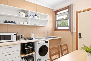 PymbleDouble Room in Gordon near Train & Bus - 1 person的厨房配有洗衣机、微波炉和桌子