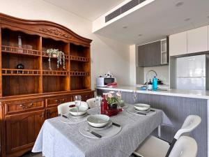 悉尼Olympic park&Luxury 2b2b1p Apt pool& Free parking的厨房配有带盘子和碗的桌子