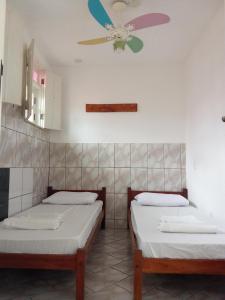 伦索伊斯Chapadão Hostel的配有吊扇的客房内的两张床