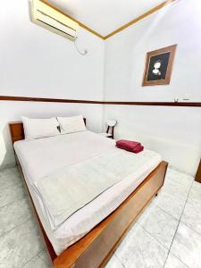 巴东Wisma Mutiara的一间卧室,卧室内配有一张大床