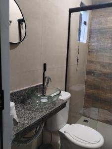 伊塔蒂亚亚Hospedagem Encantos da Serra的一间带水槽、卫生间和镜子的浴室