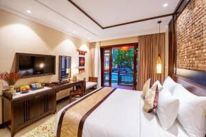 会安Ahoy Hoi An Boutique Resort & Spa的酒店客房,配有床和电视