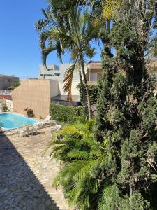 马蒂尼奥斯Pousada Volare的一个带游泳池和棕榈树的度假村