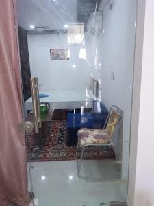 乌代浦Hotel Balaji Residency的一间带椅子和桌子的房间以及一间带Saud No B的房间