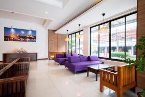 曼谷The President Hotel at Chokchai 4的一间设有紫色家具和窗户的等候室