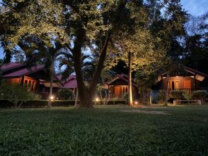 沙美岛Samed Garden Resort的夜晚在院子里有树的房子