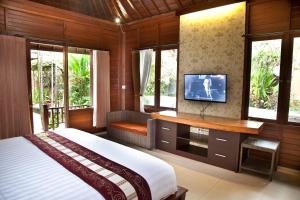库塔捷鹏巴厘岛酒店的一间卧室设有一张床、一台电视和窗户。