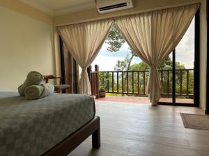 浮罗山背宝胜榴莲农场酒店的一间卧室设有一张床,享有阳台的景色