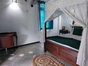 KudaweJansen’s Bungalow Sinharaja Rainforest Retreat的一间卧室配有一张天蓬床和地毯。