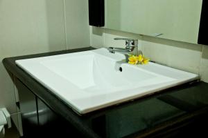 库塔捷鹏巴厘岛酒店的浴室水槽上放着黄色的花