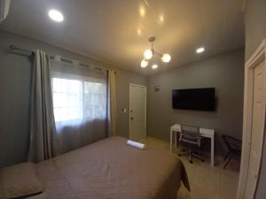 科马亚瓜Palmerola Inn的一间卧室配有一张床、一张书桌和一台电视