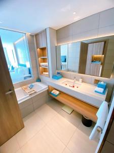 下龙湾Khách sạn A LaCarte Hạ Long - Quảng Ninh的一间带水槽、浴缸和镜子的浴室