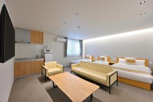 广岛GRAND BASE Hiroshima Peace Memorial Park的酒店客房设有两张床和一张桌子。
