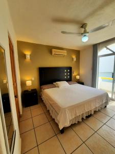 伊斯塔帕Hacienda Real Suits Ixtapa的一间卧室设有一张大床和一个窗户。